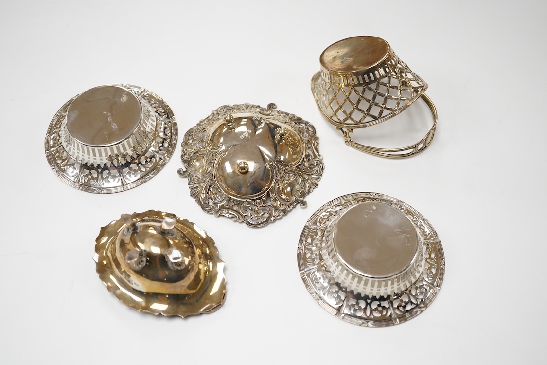 A pair of pierced silver circular bonbon dishes, maker JM, Birmingham, 1906, diameter 10.3cm, together with one other silver bonbon dish and two bonbon baskets, one silver, one stamped with U.S. sterling marks, 7.1oz.